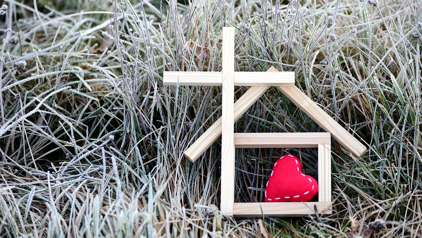 stick forming cross and house with a red heart inside.