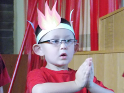 Boy with a paper crown on his head praying