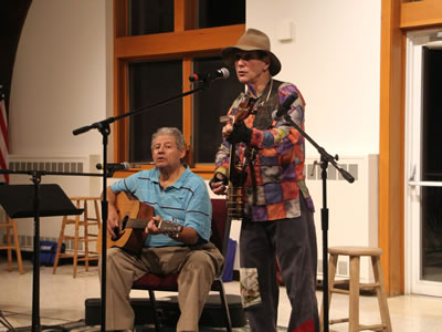 Two Coffee house performers singing ang playing guitars