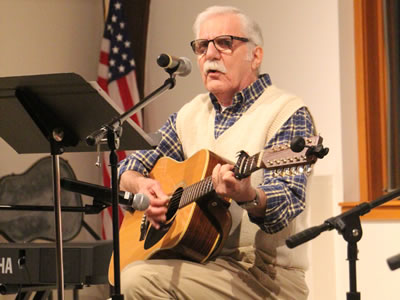 Coffee house performer singing and playing guitar