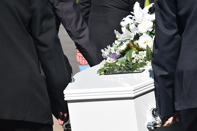 palbearers carrying white coffin