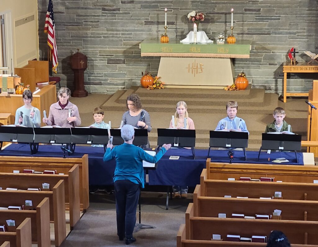 Children and adults playing the bells at church.