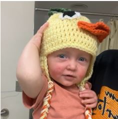 Baby with knitted duck hat on head
