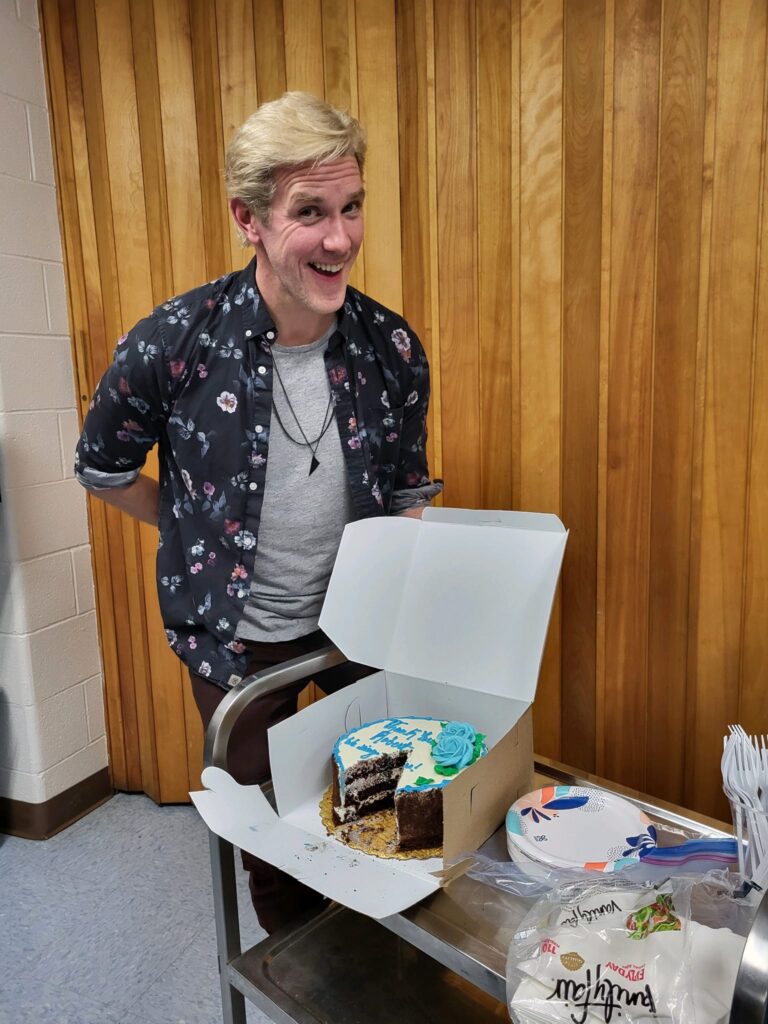 Robert Thomsen smiling with a cake.