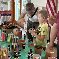 Woman and boy painting flower pots