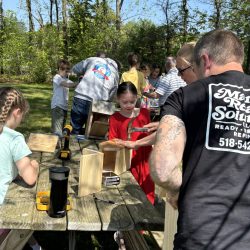 Youth making birdhouses with adult help